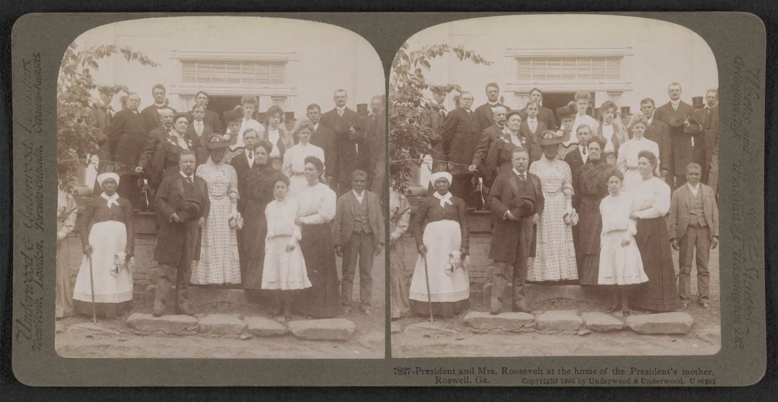 A sepia stereograph card with two near-identical side-by-side photographs of a large group of about thirty people in early-1900s dress posed on stone steps in front of a white house entrance with a wide transom window. A man in a dark frock coat holding a hat stands front left of centre, a woman in a dotted dress and a feathered hat stands beside him, and an elderly Black woman in a white apron and head wrap leaning on a cane stands at far left; an elderly Black man in a vest and jacket stands at right. The card is printed "7827 - President and Mrs. Roosevelt at the home of the President's mother, Roswell, Ga. Copyright 1905 by Underwood & Underwood", with the publisher's name in script on the side margins.