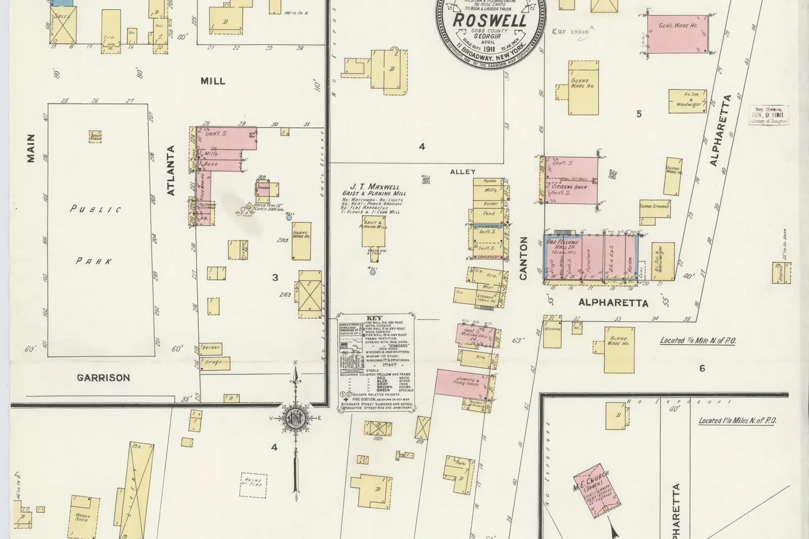 A hand-coloured fire-insurance map sheet (plate 1) of the town centre in yellow (frame), pink (brick) and blue (stone) building footprints on cream paper. Labelled streets include Canton, Atlanta, Alpharetta, Mill, Norcross, Marietta, Garrison, Main and Cemetery. A rectangle at left is marked "Public Park" between Main and Atlanta streets, and other labels include "J. T. Maxwell Grist & Planing Mill", "Odd Fellows" hall, a "M.E. Church" and "Oxbow Falls Mfg. Co." beside a creek. A round cartouche reads "Sanborn Map Company, Population 1300 ... Roswell, Cobb County, Georgia, April 1911"; a received stamp reads "May 31 1911".